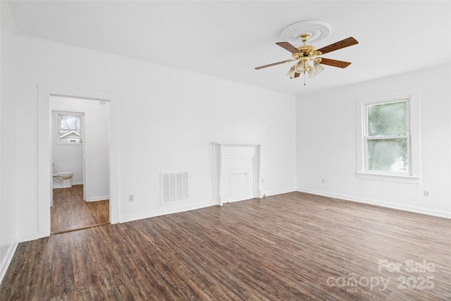 unfurnished room featuring a ceiling fan, plenty of natural light, wood finished floors, and visible vents