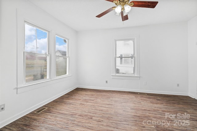 spare room with visible vents, baseboards, and wood finished floors