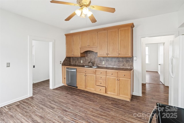 kitchen with visible vents, a sink, backsplash, freestanding refrigerator, and dishwasher