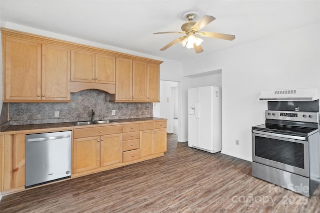 kitchen with dark wood finished floors, appliances with stainless steel finishes, exhaust hood, and a sink