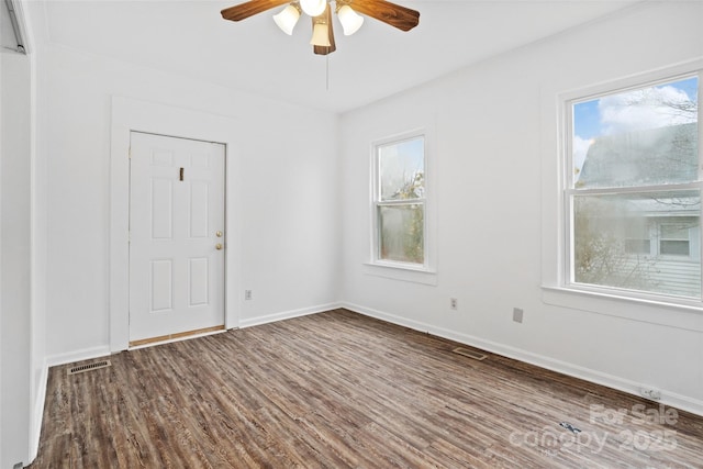 empty room with visible vents, baseboards, and wood finished floors