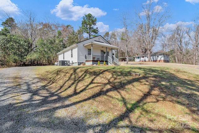 view of front of property with a porch, a front lawn, driveway, and crawl space