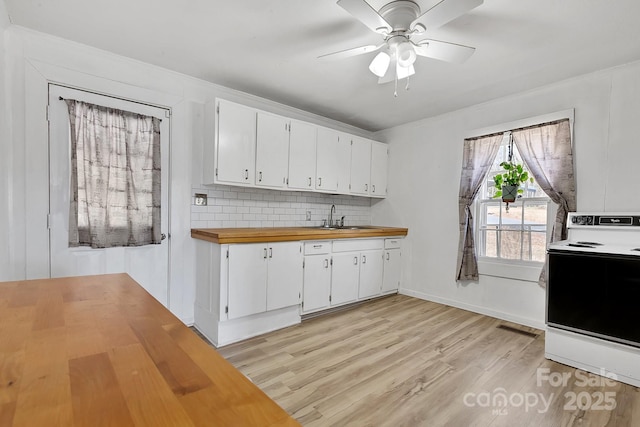 kitchen with light wood-type flooring, white range with electric cooktop, a sink, backsplash, and wooden counters