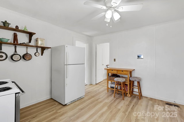 kitchen with visible vents, white appliances, light wood-type flooring, and ceiling fan