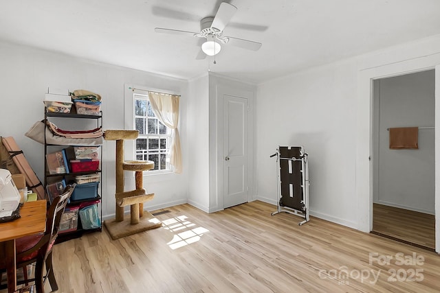 interior space featuring baseboards, wood finished floors, and a ceiling fan