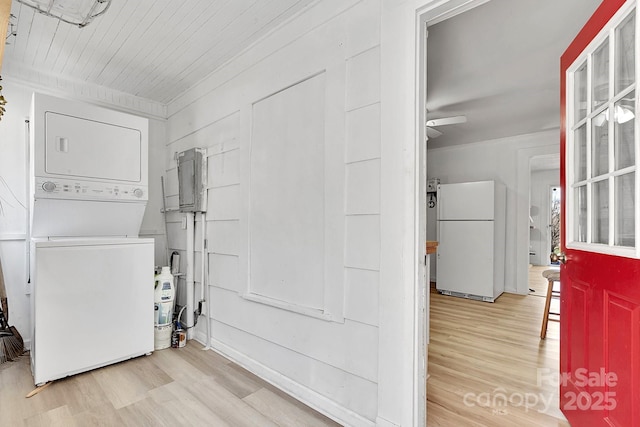 washroom featuring stacked washer / drying machine, a ceiling fan, and wood finished floors