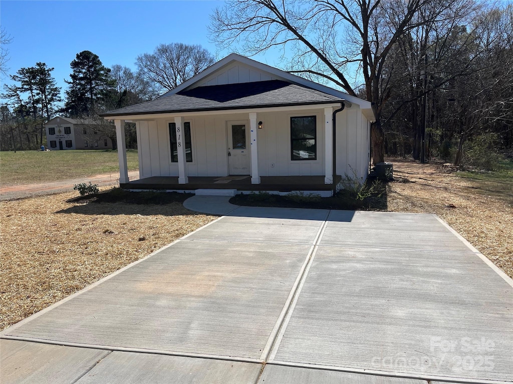 view of front of home with board and batten siding, a porch, and a shingled roof