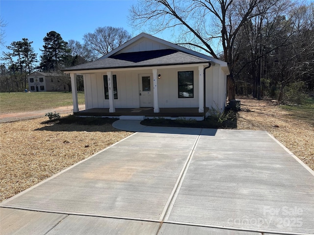 view of front of home with board and batten siding, a porch, and a shingled roof