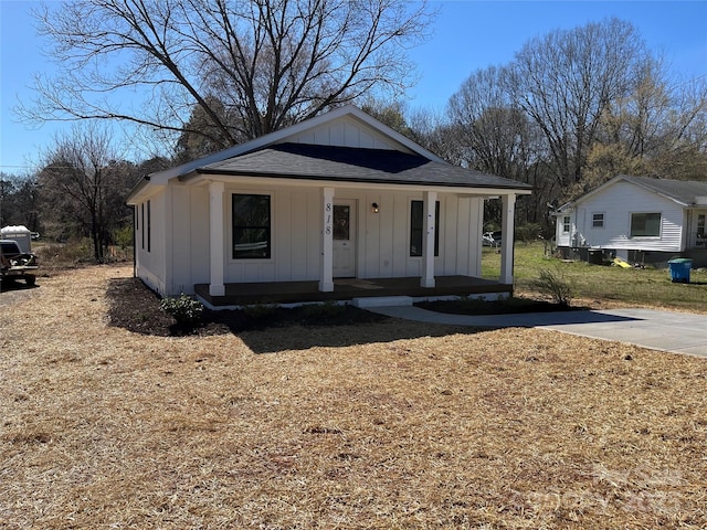 bungalow-style home with covered porch, board and batten siding, and a shingled roof