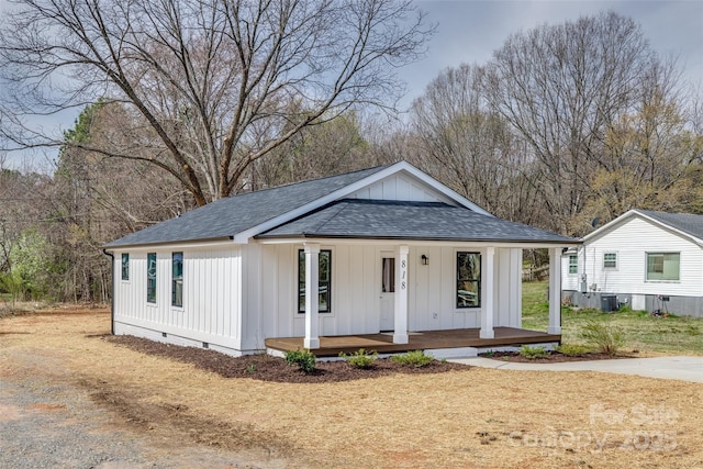 view of front of property featuring central AC unit, a porch, a shingled roof, crawl space, and board and batten siding