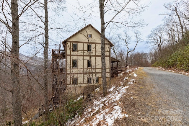 exterior space featuring stucco siding and gravel driveway