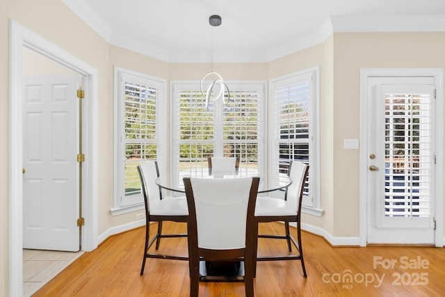 dining area featuring wood finished floors, a healthy amount of sunlight, and ornamental molding