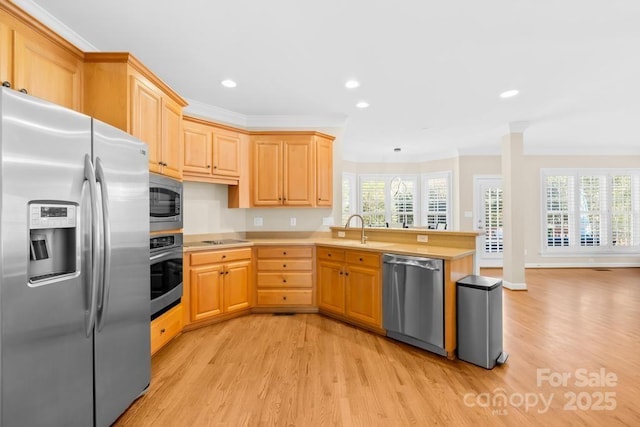 kitchen featuring light brown cabinets, appliances with stainless steel finishes, a peninsula, crown molding, and light countertops