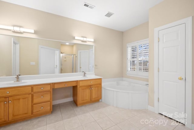 bathroom featuring double vanity, a garden tub, visible vents, and a sink