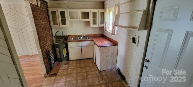 819 Circle Vw, Gastonia, NC 28054 - kitchen with a sink, water heater, dark countertops, glass insert cabinets, and brick wall