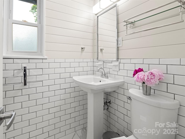 bathroom with tile walls and toilet