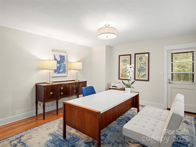 office area with baseboards and wood finished floors