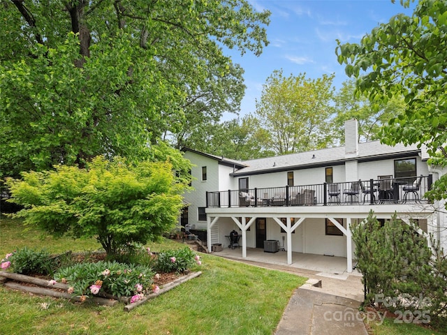 back of house featuring stairway, central AC unit, a chimney, a deck, and a patio