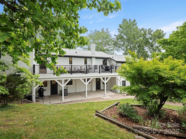 rear view of house featuring a patio, a wooden deck, a yard, a chimney, and central air condition unit