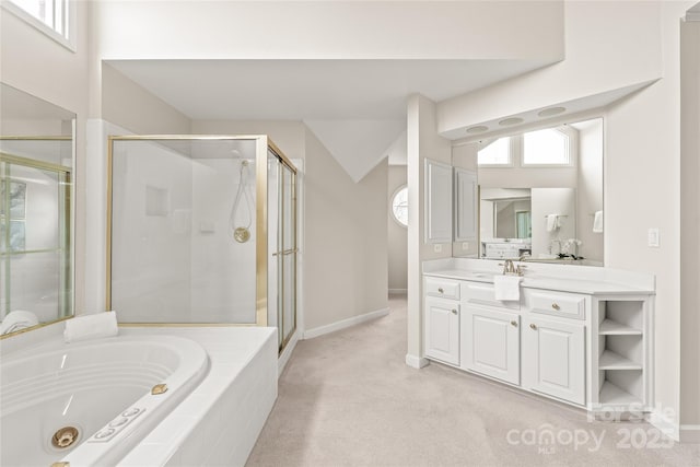 bathroom with baseboards, vanity, a jetted tub, and a shower stall