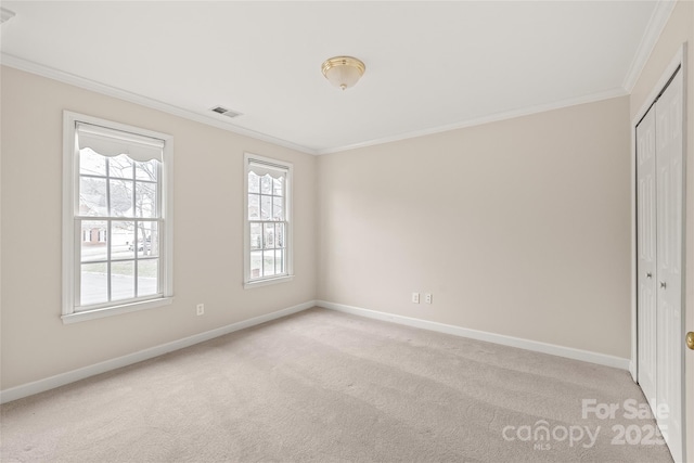 interior space with visible vents, light colored carpet, baseboards, and ornamental molding