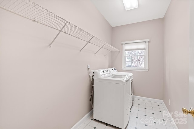 laundry area with washer and dryer, laundry area, light floors, and baseboards