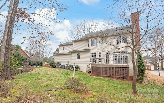 back of house featuring a deck, a lawn, central AC, and a chimney