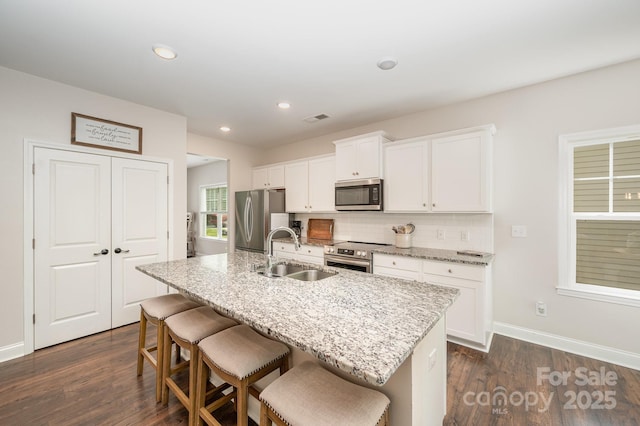 9428 Segundo Ln, Charlotte, NC 28278 - kitchen with stainless steel appliances, a sink, a center island with sink, visible vents, and dark wood-type flooring