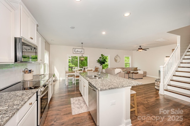 9428 Segundo Ln, Charlotte, NC 28278 - kitchen featuring recessed lighting, stainless steel appliances, a sink, tasteful backsplash, and white cabinetry