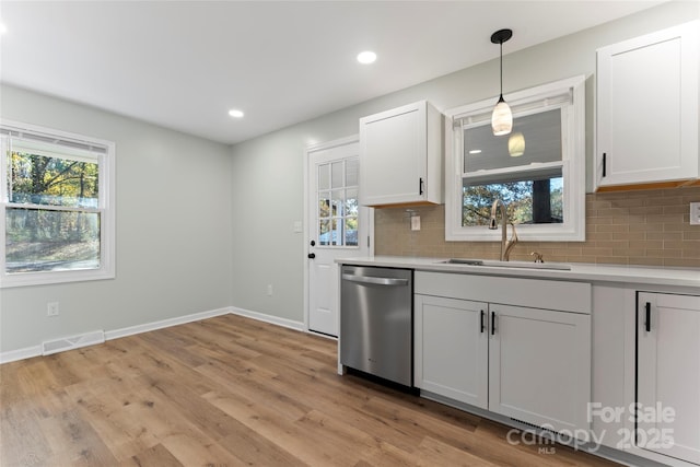 kitchen with visible vents, a sink, backsplash, light countertops, and dishwasher