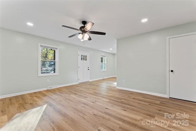 interior space with visible vents, light wood-style flooring, baseboards, and a healthy amount of sunlight