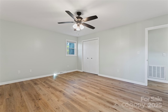 spare room featuring visible vents, baseboards, a ceiling fan, and light wood finished floors