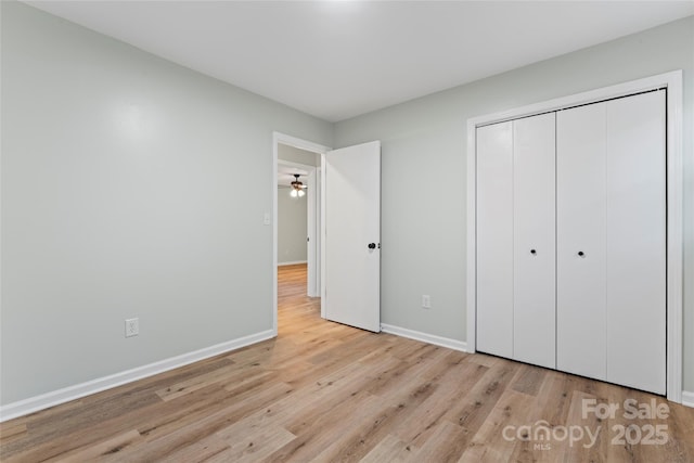 unfurnished bedroom featuring a closet, baseboards, and light wood finished floors