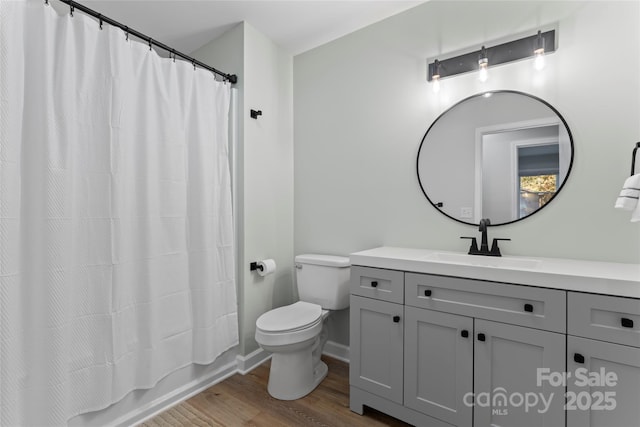 full bath featuring vanity, toilet, wood finished floors, and baseboards