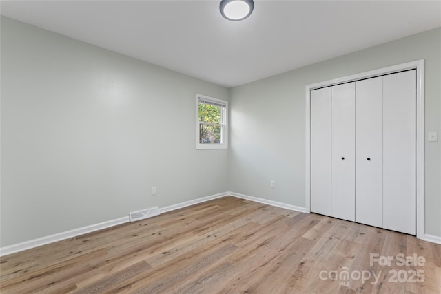 unfurnished bedroom featuring visible vents, baseboards, and light wood-style flooring