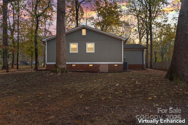 property exterior at dusk featuring crawl space, cooling unit, and fence