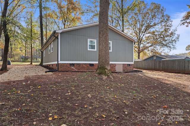 view of property exterior featuring crawl space and fence