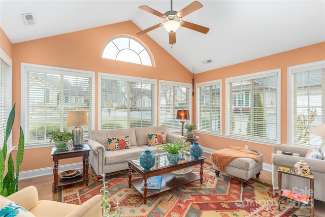 sunroom featuring visible vents, lofted ceiling, and ceiling fan