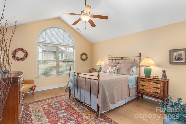 bedroom with a ceiling fan, visible vents, baseboards, lofted ceiling, and light wood-style flooring