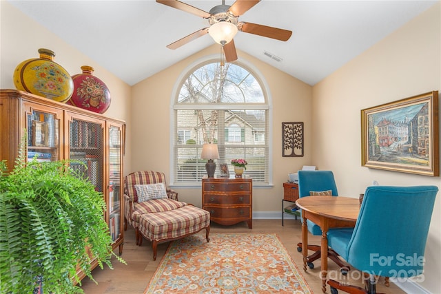 home office with visible vents, light wood-type flooring, a ceiling fan, and vaulted ceiling