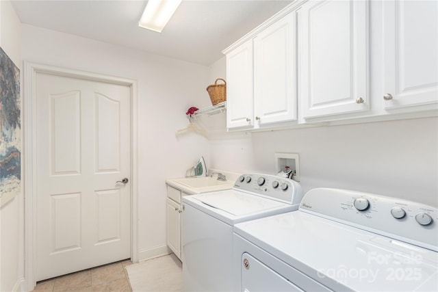 laundry area featuring cabinet space, light tile patterned floors, washer and dryer, and a sink