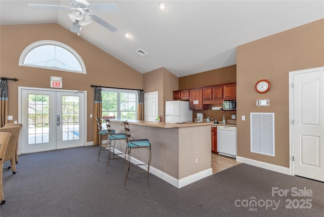 kitchen with carpet flooring, white appliances, french doors, and visible vents