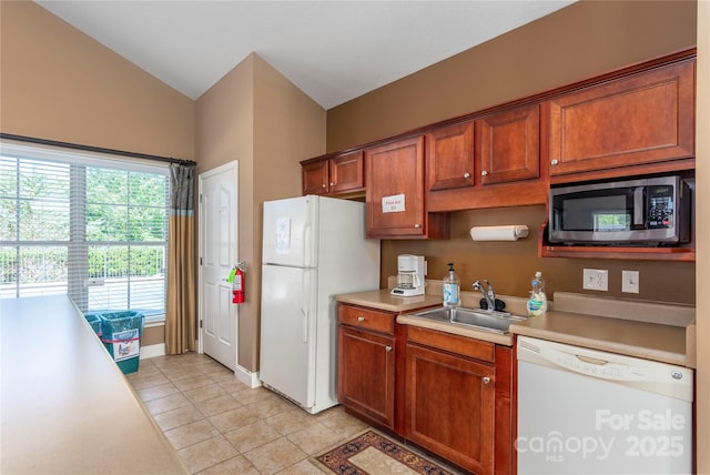 kitchen with light tile patterned floors, white appliances, light countertops, and a sink