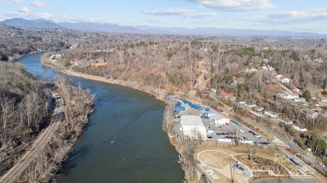 aerial view featuring a forest view and a water and mountain view