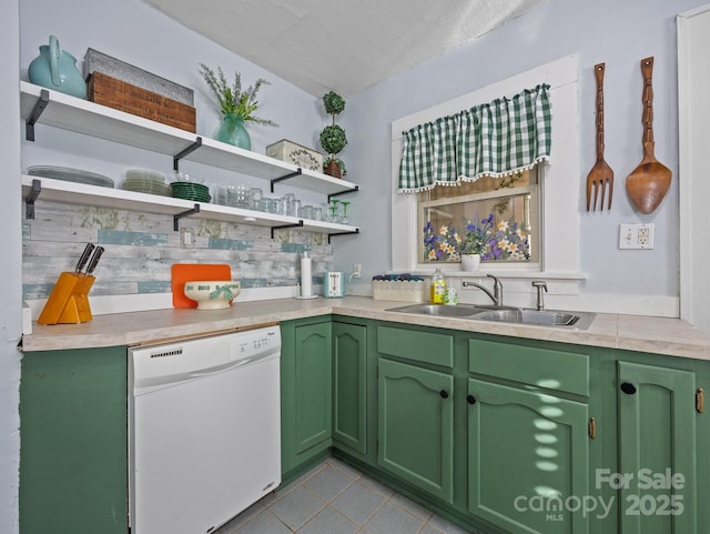 kitchen featuring open shelves, light countertops, light tile patterned floors, white dishwasher, and a sink