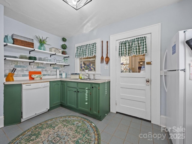 kitchen with white appliances, open shelves, a sink, light countertops, and green cabinets