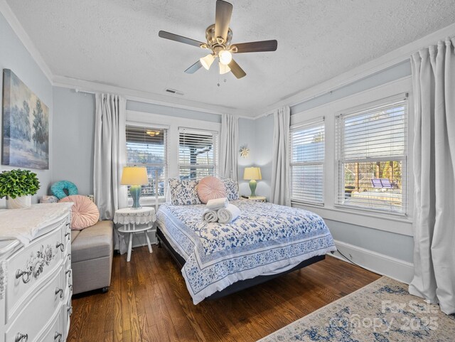 bedroom with visible vents, dark wood-type flooring, baseboards, ceiling fan, and a textured ceiling