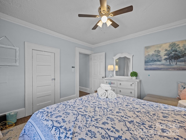 bedroom featuring wood finished floors, baseboards, ceiling fan, a textured ceiling, and crown molding