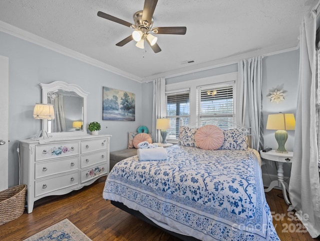 bedroom with visible vents, a ceiling fan, a textured ceiling, crown molding, and dark wood-style flooring