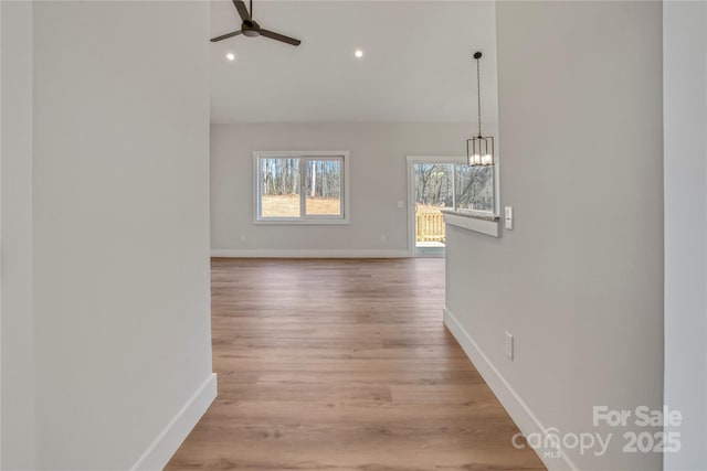 interior space featuring recessed lighting, baseboards, wood finished floors, and ceiling fan with notable chandelier